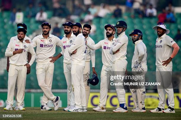 India's cricketers wait for the third umpire's decision for the dismissal of Bangladesh's Nurul Hasan during the second day of the first cricket Test...