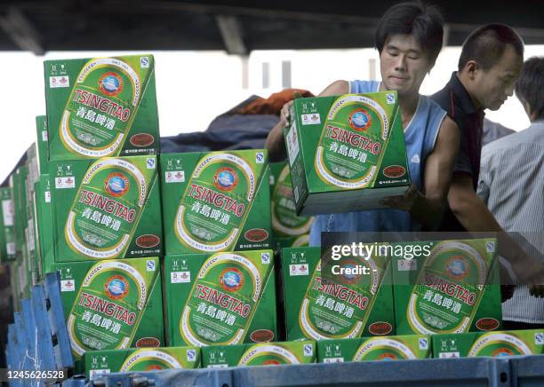 Workers load boxes of Tsingtao beer on to a truck at one of the four breweries in the eastern Chinese port city of Qingdao 23 August 2006. Tsingtao,...