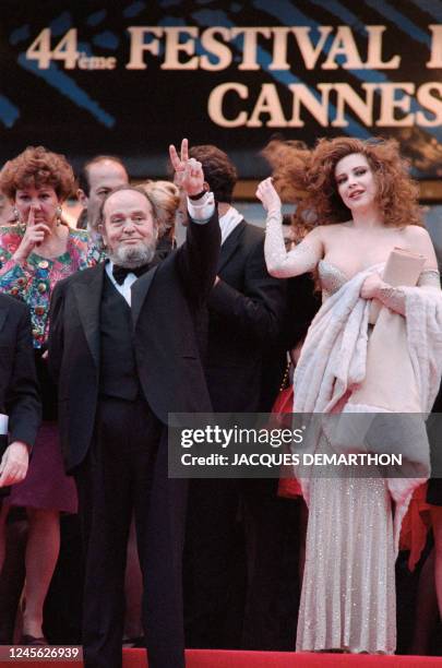 Italian director Marco Ferreri and actress Francesca Dellera wave to the crowd following the showing of the film "The Flesh", on May 13 at the 44th...