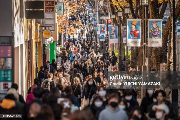 People walk through a shopping street in Omotesando area of Tokyo on December 15, 2022.