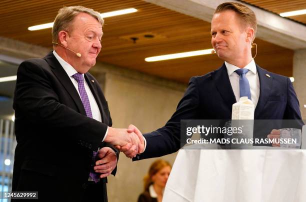 Outgoing Danish Foreign Minister Jeppe Kofod shakes hands with new Danish Foreign Minister Lars Lokke Rasmussen during a handover of the Foreign...