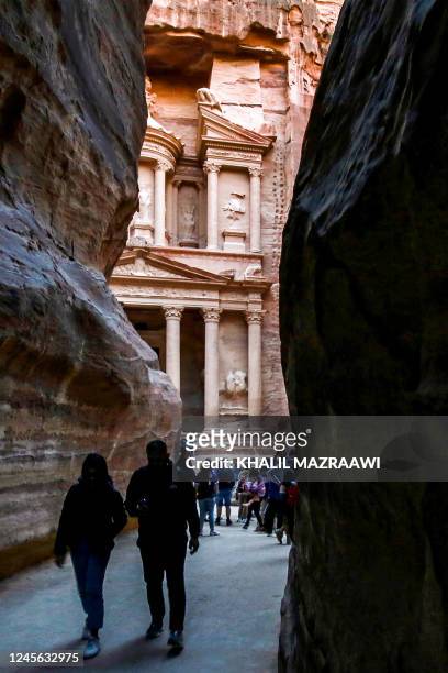 Visitors tour near the Treasury at the ruins of the ancient Nabatean city of Petra in southern Jordan on on December 12, 2022.