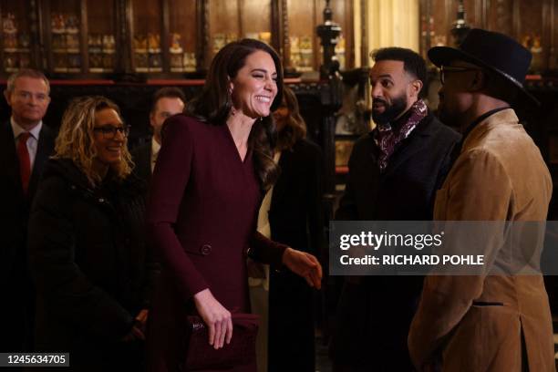 Britain's Catherine, Princess of Wales speaks with guests as she arrives to attend the "Together At Christmas Carol Service" at Westminster Abbey, in...