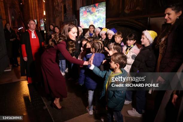 Britain's Catherine, Princess of Wales speaks children as she arrives to attend the "Together At Christmas Carol Service" at Westminster Abbey, in...