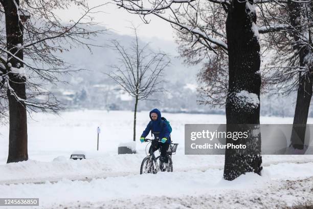 Cyclist is seen riding a bicycle through Blonia park covered with snow during snowfall in the city as Arctic blast heads for Europe. Krakow, Poland...