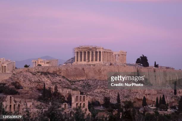 View of Parthenon Temple on Acropolis Hill during the sunset in Athens, Greece on December 15, 2022.