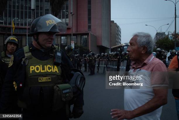 Demonstrator speaks with a riot police officer during protests on Avenida de Pierola in Lima, Peru, on Thursday, Dec. 15, 2022. Peru has declared a...