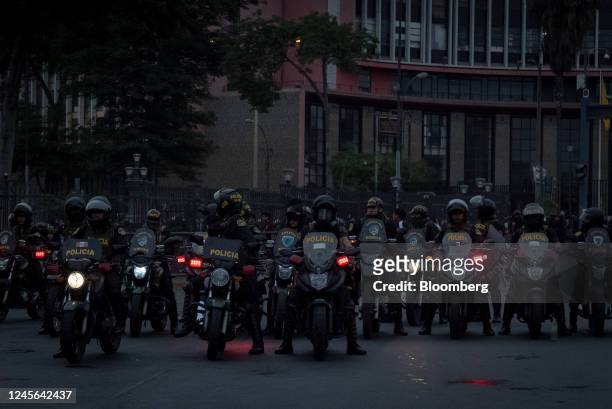 Riot police officers on motorcycles stand guard during protests on Avenida de Pierola in Lima, Peru, on Thursday, Dec. 15, 2022. Peru has declared a...