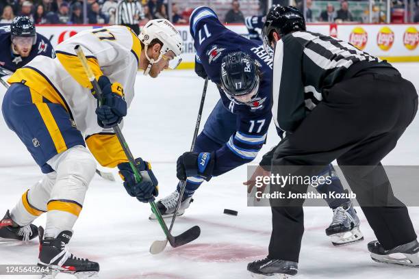 Mark Jankowski of the Nashville Predators takes a second period face-off against Adam Lowry of the Winnipeg Jets at the Canada Life Centre on...