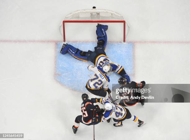 Jordan Binnington of the St. Louis Blues secures the puck with players in front of the net during the game against the Edmonton Oilers on December...