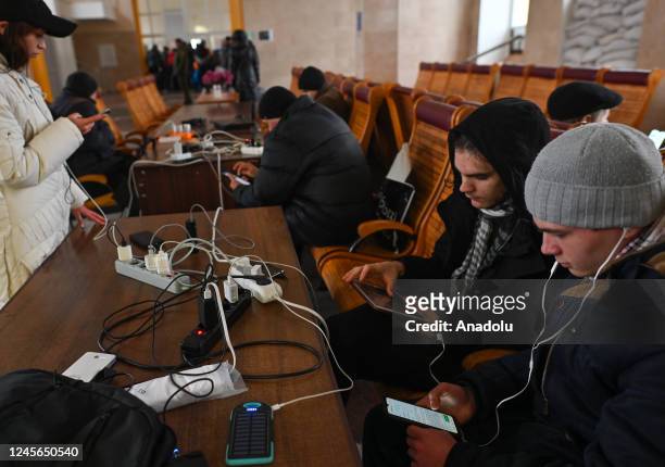 People charging phones and laptops inside the train station in Kherson, Ukraine, on December 15, 2022. A month after liberation, the Ukrainian city...