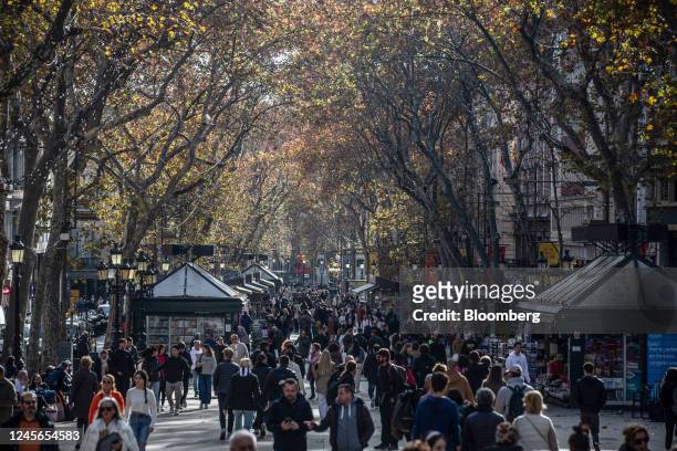 Crowds of tourists and shoppers make their way along Las Ramblas in Barcelona, Spain, on Friday, Dec. 16, 2022. Consumer prices across Spain eased...