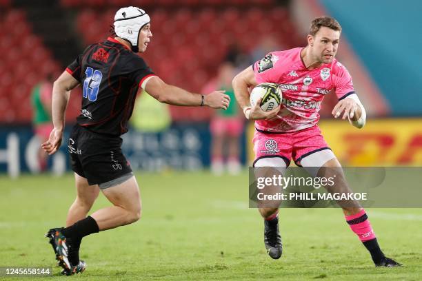 Stade Francais' wing Harry Glover runs with the ball as Lions' center Henco van Wyk marks him during the European Challenge Cup Pool B rugby union...