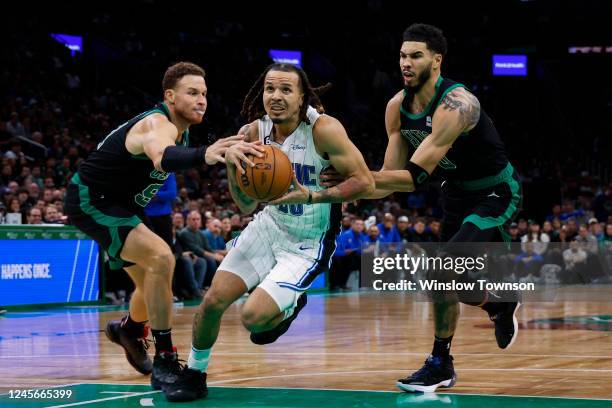 Cole Anthony of the Orlando Magic goes between Blake Griffin and Jayson Tatum of the Boston Celtics during the second half of the game at TD Garden...