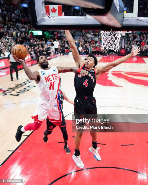 Kyrie Irving of the Brooklyn Nets goes to the basket against Scottie Barnes of the Toronto Raptors during the second half of their basketball game at...