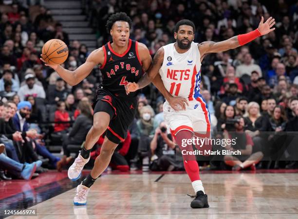 Scottie Barnes of the Toronto Raptors drives against Kyrie Irving of the Brooklyn Nets during the second half of their basketball game at the...