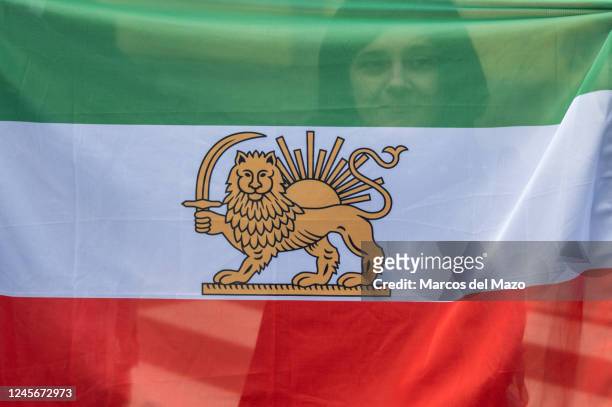 Woman is seen behind an Iranian flag during a protest against executions in Iran outside the Iranian embassy in Madrid. The Iranian community has...