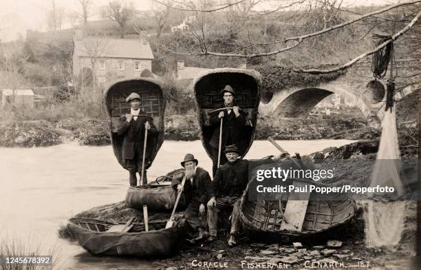 Coracle fishermen on the banks of the River Teifi in Cenarth, Wales, circa 1900.