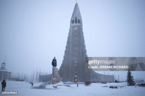 Photo taken on December 17, 2022 shows the Hallgrimskirkja church and the Leif Eriksson Memorial during snowfall in downtown Reykjavik, Iceland. -...