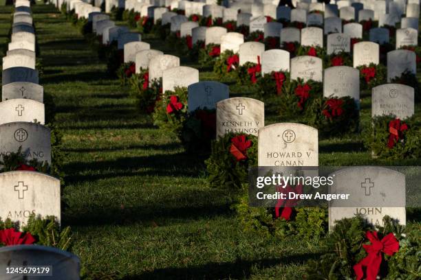 Christmas wreaths placed by volunteers sit in front of headstones at Arlington National Cemetery on December 17, 2022 in Arlington, Virginia....