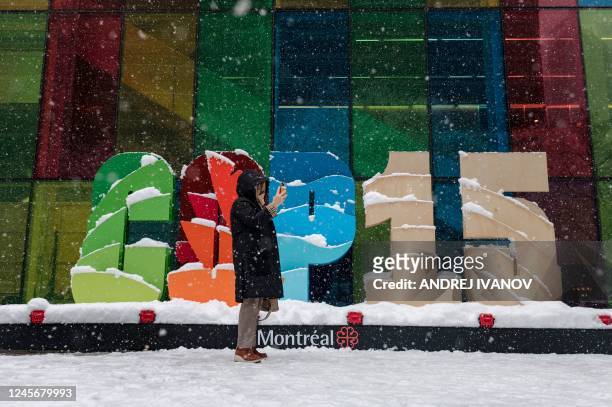 Person takes a picture by the COP15 logo in front of the Palais des Congres at the United Nations Biodiversity Conference in Montreal, Quebec, Canada...