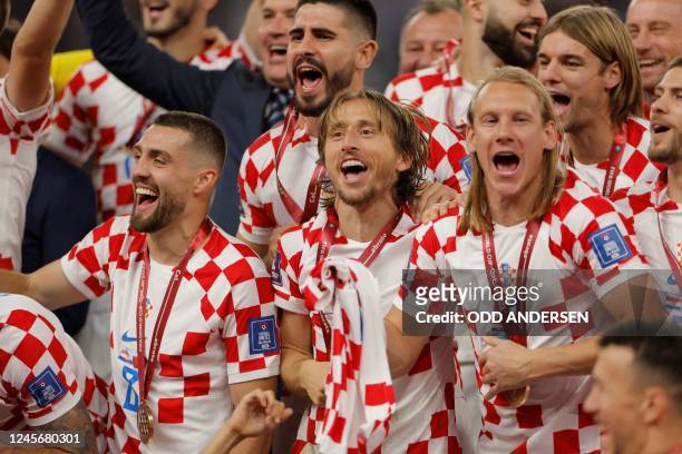 Croatia's midfielder Luka Modric , Croatia's midfielder Mateo Kovacic and Croatia's defender Domagoj Vida celebrate after winning the Qatar 2022...
