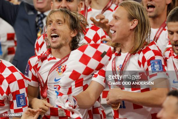 Croatia's midfielder Luka Modric and Croatia's defender Domagoj Vida celebrate after winning the Qatar 2022 World Cup third place play-off football...
