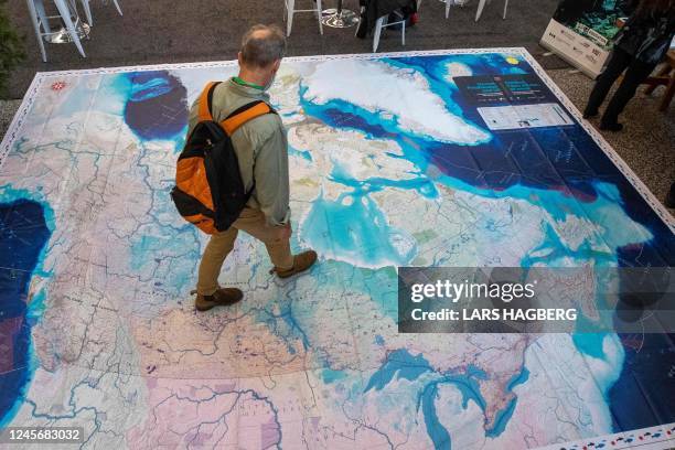 Person explores a giant map of Canada during the United the Nations Biodiversity Conference in Montreal, Quebec, Canada, on December 17, 2022. -...
