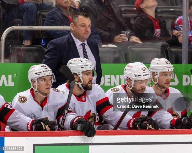 Head coach D. J. Smith of the Ottawa Senators watches the action from the bench against the Detroit Red Wings during the first period of an NHL game...