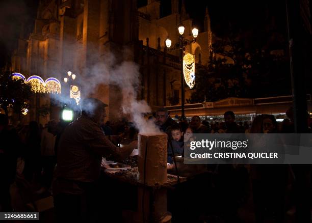 People buy roasted chestnuts at a street stand next to the cathedral in Seville on December 17 ahead of Christmas holidays.