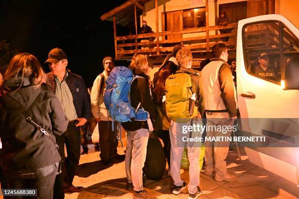 Stranded tourists who were visiting the Inca citadel of Machu Picchu wait to board a van to travel to Cusco after being evacuated by train to...