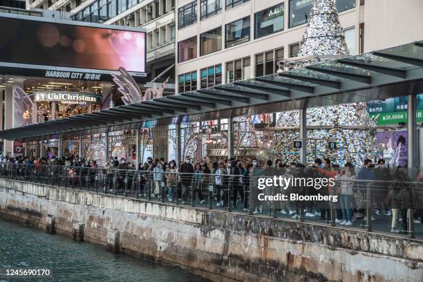 Visitors walk past the Christmas installation outside Harbour City shopping mall in Hong Kong, China, on Saturday, Dec. 17, 2022. Hong Kong is...