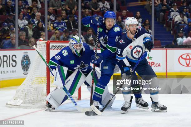 Goaltender Spencer Martin and Vancouver Canucks defenseman Riley Stillman defend against Winnipeg Jets right wing Sam Gagner during their NHL game at...