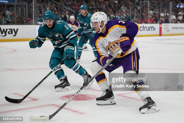 Matt Benning of the San Jose Sharks and Matt Roy of the Los Angeles Kings battle for position during the first period at Crypto.com Arena on December...
