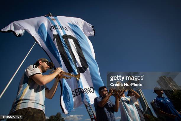 People play music as a huge Argentina shirt with soccer star Lionel Messi's surname is displayed at the National Flag Memorial ahead of the World Cup...