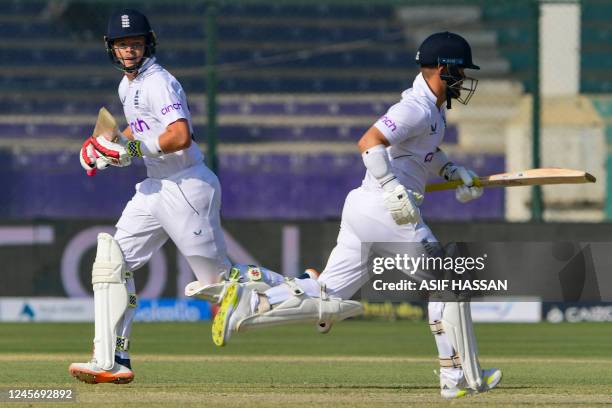 England's Ollie Pope and Ben Duckett run between the wickets during the second day of the third cricket Test match between Pakistan and England at...