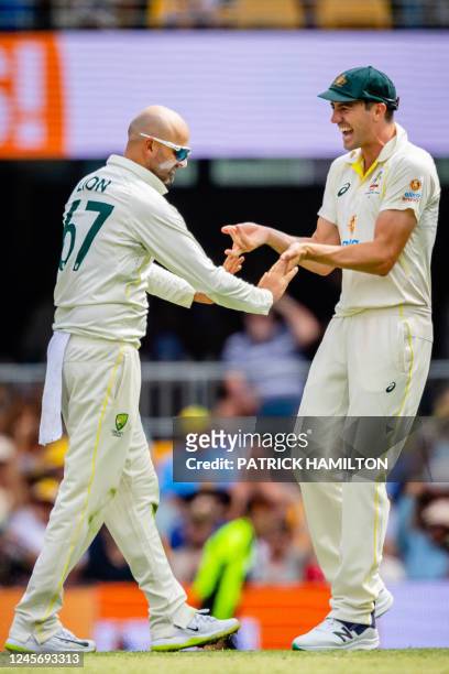 Australia's Nathan Lyon and Pat Cummins celebrate the dismissal of South Africa's Temba Bavuma during day two of the first cricket Test match between...