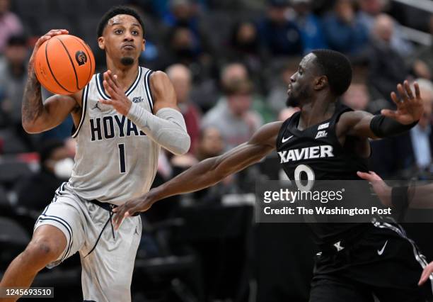 Georgetown Hoyas guard Primo Spears , left, scores past Xavier Musketeers guard Souley Boum during a game between the Georgetown Hoyas and the Xavier...