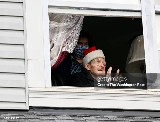 Mr. Vincent Gibbs applauds his former students from his bedroom window as they gather at his home to sing Christmas carols, read speeches and offer a...