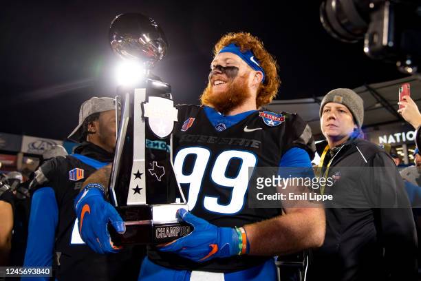 Defensive tackle Scott Matlock of the Boise State Broncos smiles with the Frisco Bowl trophy after winning the game against the North Texas Mean...