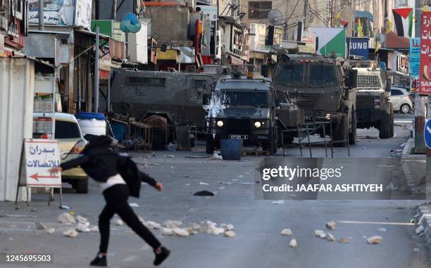 Palestinian protesters hurl rocks at members of the Israeli army during a reported raid in the Palestinian Askar refugee camp near Nablus in the...