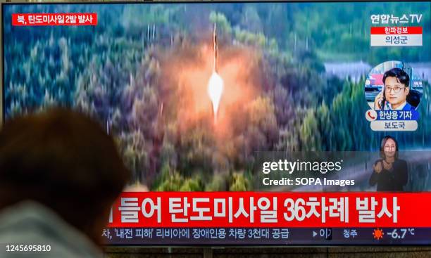 Viewer watches a television screen showing a news broadcast with file footage of a North Korean missile launch at Yongsan railway station in Seoul....