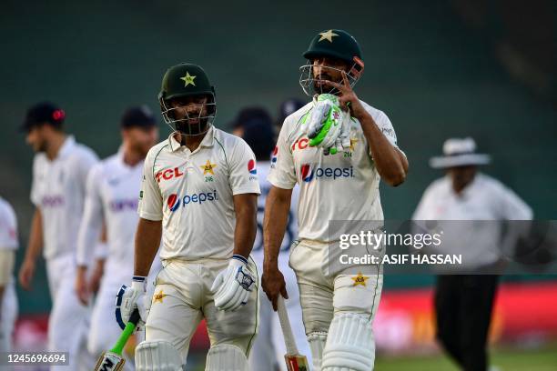 Pakistan's Abdullah Shafique and Shan Masood walk back to the pavilion at the end of play of second day of the third cricket Test match between...