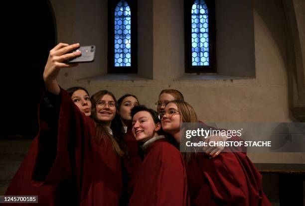 Members of the Regensburger Domspatzen girls' choir take a group selfie prior to their first appearance during a service at the Regensburg Cathedral...