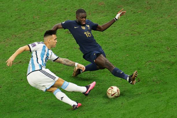 Argentina's forward Lautaro Martinez attempts a shot at goal to be blocked by France's defender Dayot Upamecano during the Qatar 2022 World Cup...