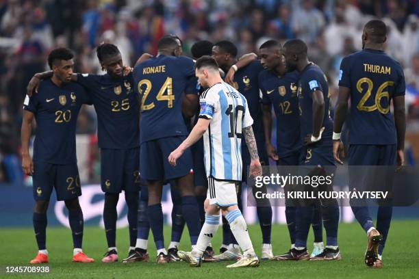 Argentina's forward Lionel Messi walks past France players as he prepares to take a shot in the penalty shootout during the Qatar 2022 World Cup...