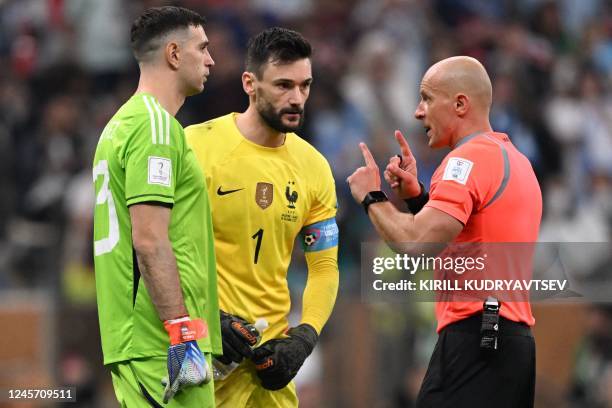 Polish referee Szymon Marciniak talks with Argentina's goalkeeper Emiliano Martinez and France's goalkeeper Hugo Lloris before the penalty shootout...