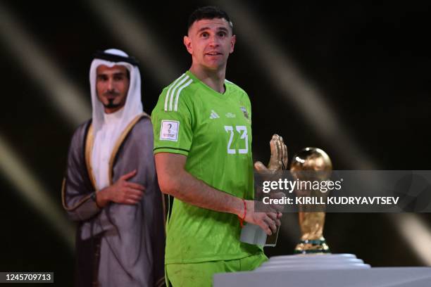 Argentina's goalkeeper Emiliano Martinez poses with the FIFA Golden Glove award during the trophy ceremony at the end of the Qatar 2022 World Cup...