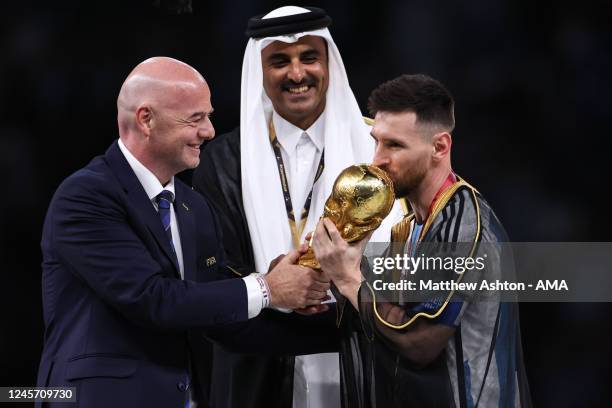 Lionel Messi of Argentina receives the FIFA World Cup Trophy Tamim bin Hamad Al Thani the Emir of Qatar and Gianni Infantino the president of FIFA...