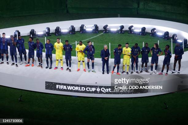 France's team poses on the podium with their silver medals during the Qatar 2022 World Cup trophy ceremony after losing the football final match...